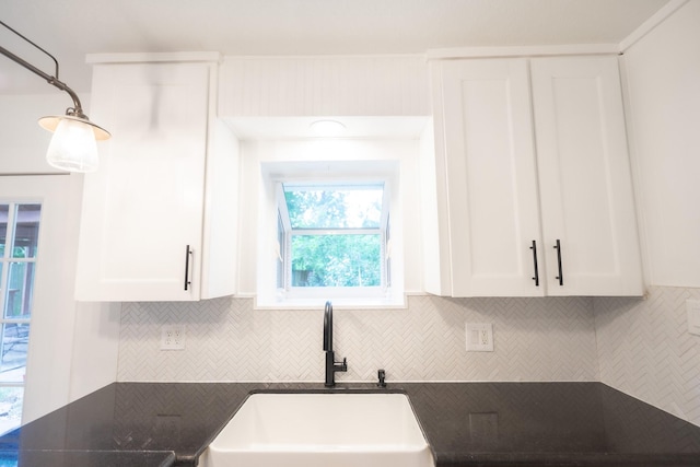 1025 Hathaway Ln, Marque, TX 77568 - kitchen featuring dark countertops, decorative backsplash, white cabinetry, and decorative light fixtures