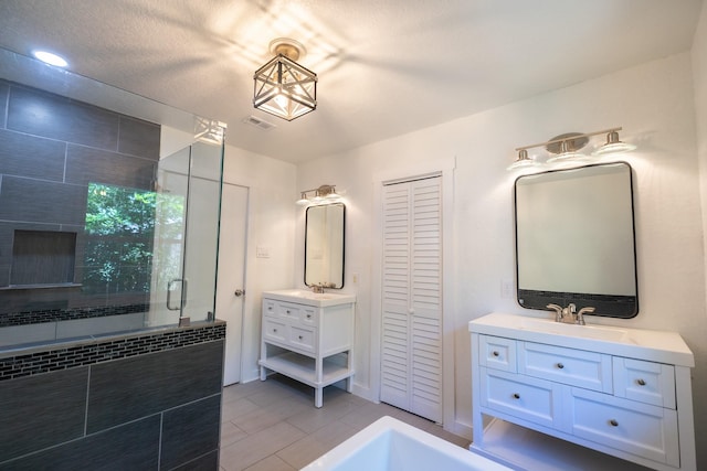 1025 Hathaway Ln, Marque, TX 77568 - full bathroom featuring a shower stall, a closet, two vanities, and tile patterned floors
