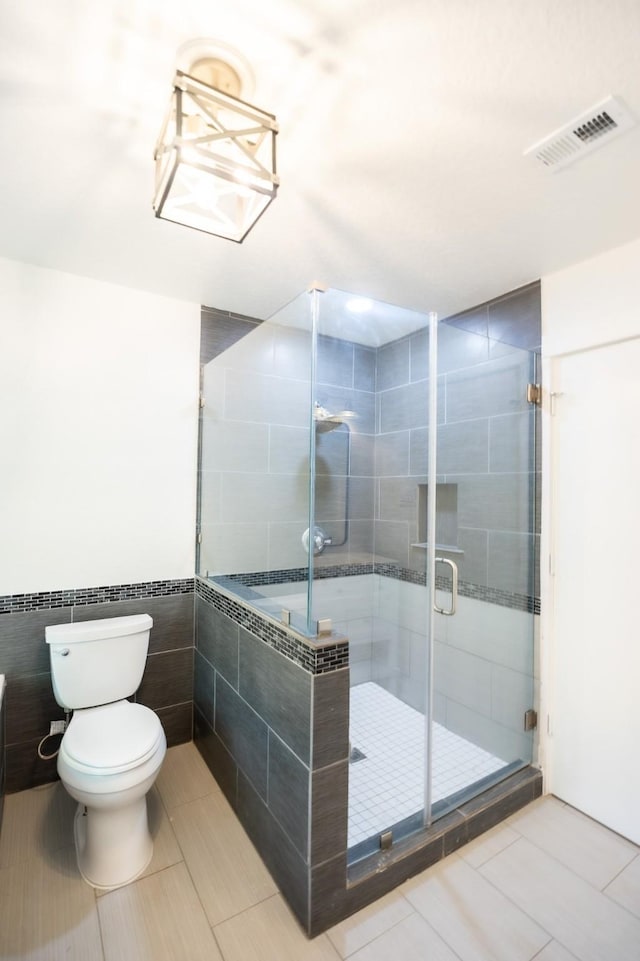 1025 Hathaway Ln, Marque, TX 77568 - bathroom with a shower stall, tile patterned floors, tile walls, and wainscoting