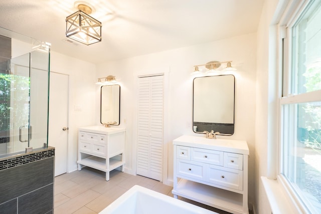 1025 Hathaway Ln, Marque, TX 77568 - bathroom featuring two vanities, a shower stall, and a bath