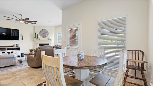 15314 Icet Creek Ave, Mont Belvieu, TX 77523 - dining room with ceiling fan, a fireplace, and light tile patterned floors