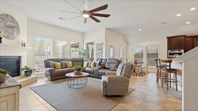 15314 Icet Creek Ave, Mont Belvieu, TX 77523 - living room with a ceiling fan, recessed lighting, light tile patterned floors, lofted ceiling, and a glass covered fireplace