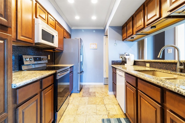 325 Carolcrest Ln Unit 2, Livingston, TX 77351 - kitchen with white appliances, stone tile floors, backsplash, light stone countertops, and ornamental molding