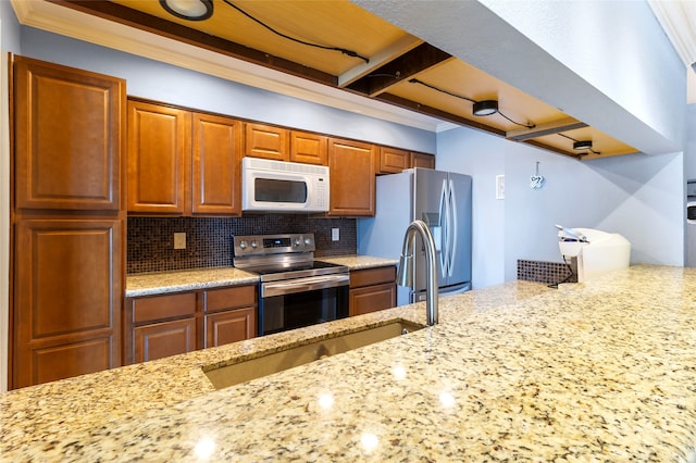 325 Carolcrest Ln Unit 2, Livingston, TX 77351 - kitchen with appliances with stainless steel finishes, ornamental molding, tasteful backsplash, light stone counters, and brown cabinetry