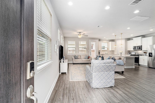 4101 Split Ivy Dr, Houston, TX 77080 - living room with healthy amount of natural light, wood finished floors, recessed lighting, and a ceiling fan