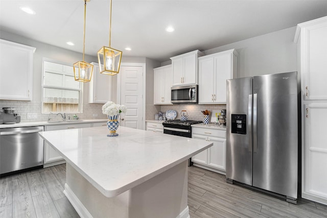 4101 Split Ivy Dr, Houston, TX 77080 - kitchen featuring appliances with stainless steel finishes, white cabinetry, a center island, tasteful backsplash, and recessed lighting