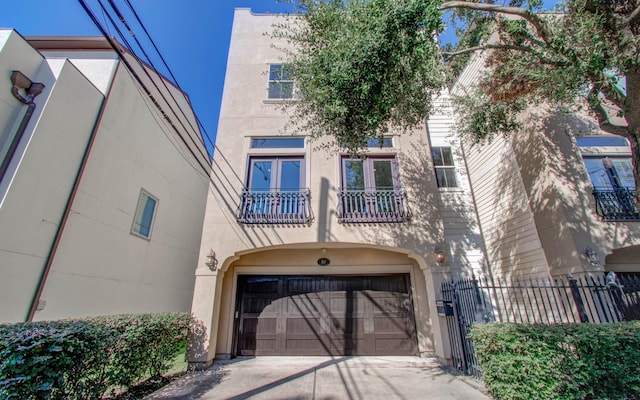 517 Fowler St, Houston, TX 77007 - view of property with stucco siding, a garage, a balcony, and concrete driveway