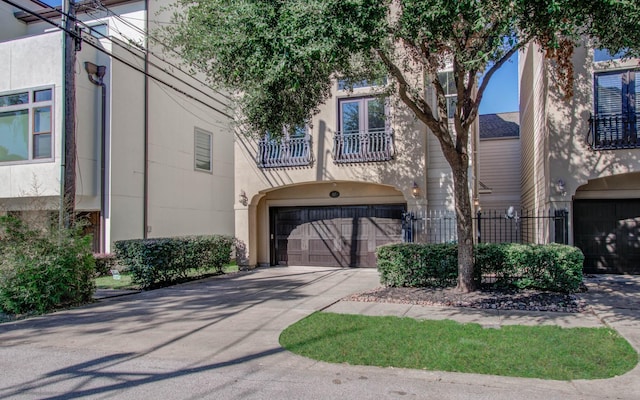 517 Fowler St, Houston, TX 77007 - view of property with a balcony, a garage, driveway, and stucco siding