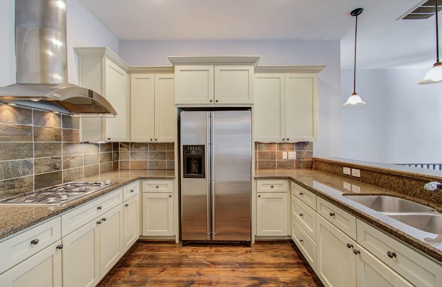 517 Fowler St, Houston, TX 77007 - kitchen featuring stainless steel fridge with ice dispenser, wall chimney exhaust hood, gas stovetop, hanging light fixtures, and dark wood-style floors