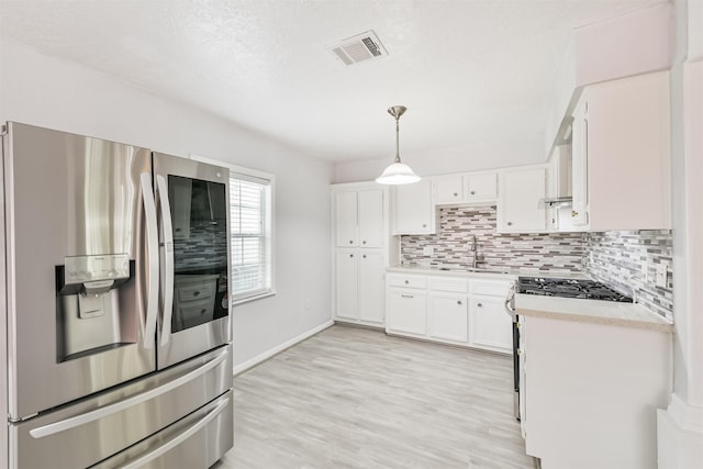 10329 Fairfax St, Houston, TX 77029 - kitchen with appliances with stainless steel finishes, light countertops, backsplash, and white cabinetry