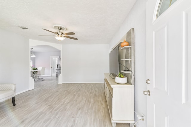 10329 Fairfax St, Houston, TX 77029 - hall with arched walkways, light wood-style flooring, and a textured ceiling
