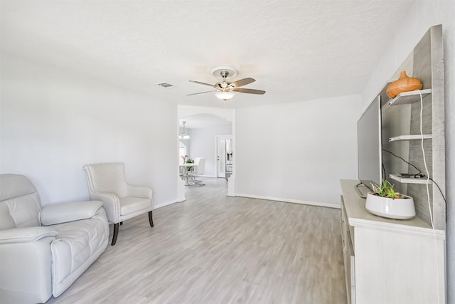 10329 Fairfax St, Houston, TX 77029 - sitting room featuring ceiling fan, light wood-style floors, arched walkways, and a textured ceiling