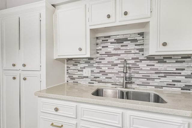 10329 Fairfax St, Houston, TX 77029 - kitchen featuring decorative backsplash, white cabinetry, and light stone countertops