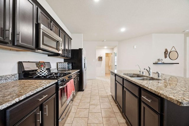 9618 Paloma Creek Dr, Tomball, TX 77375 - kitchen with stainless steel appliances, light stone countertops, a center island with sink, light tile patterned flooring, and recessed lighting