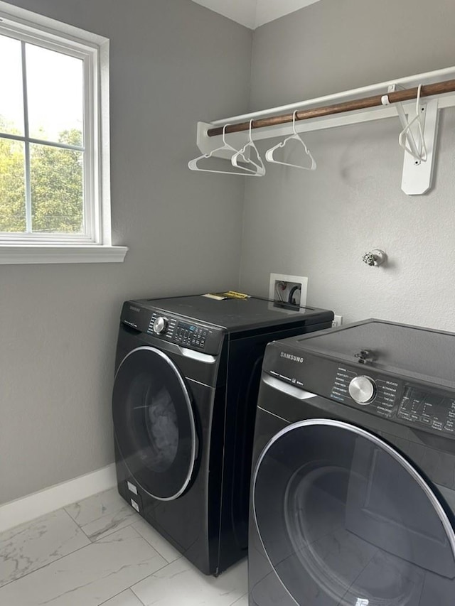 10747 Dulcimer St, Houston, TX 77051 - laundry area with washer and dryer and light marble finish floors