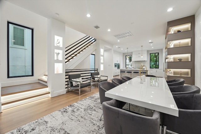 507 W Bell, Houston, TX 77019 - kitchen featuring light wood-type flooring, recessed lighting, pendant lighting, a large island with sink, and open floor plan