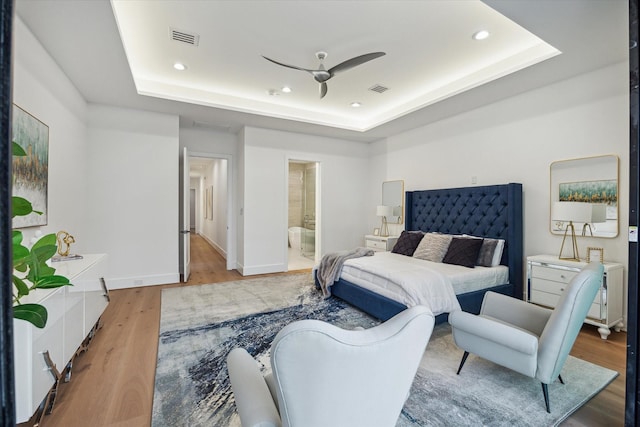 507 W Bell, Houston, TX 77019 - bedroom with a raised ceiling, light wood-style floors, recessed lighting, and ensuite bathroom
