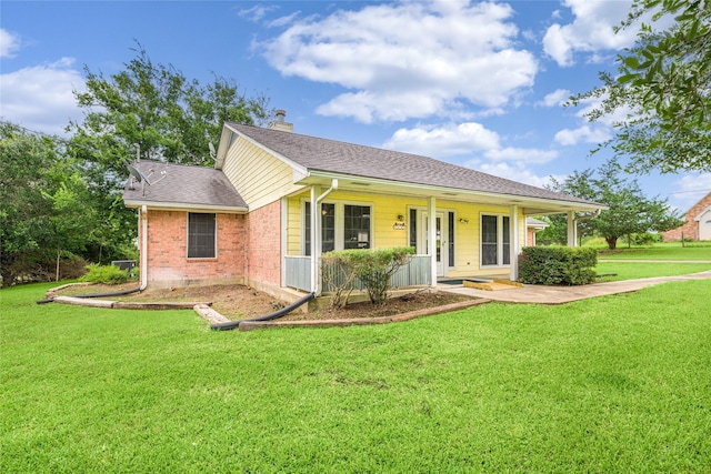 7027 Kurt Dr, Brenham, TX 77833 - ranch-style house featuring a front lawn, brick siding, a chimney, covered porch, and roof with shingles
