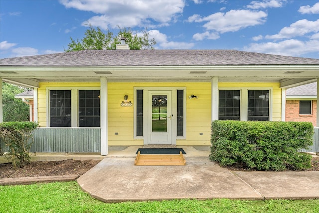 7027 Kurt Dr, Brenham, TX 77833 - entrance to property featuring a chimney, a porch, and roof with shingles