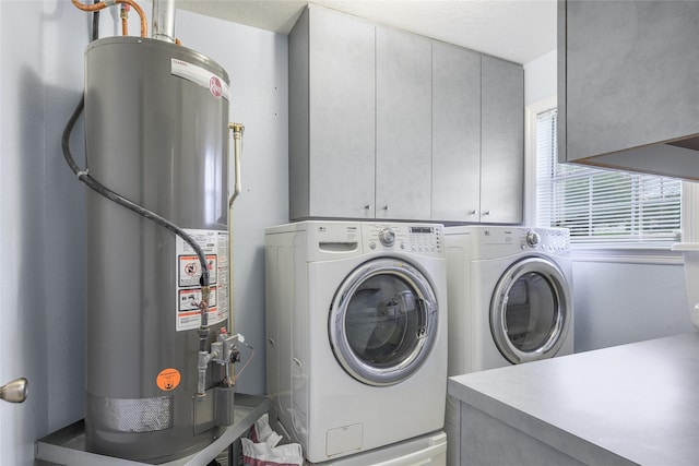 7027 Kurt Dr, Brenham, TX 77833 - laundry room featuring gas water heater, cabinet space, and washer and dryer