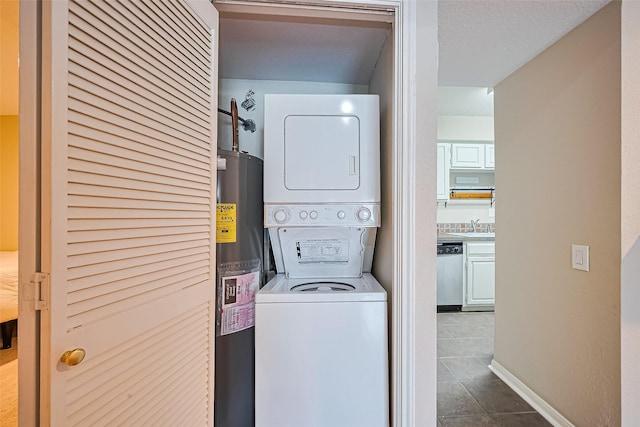 1860 White Oak Dr Unit 334, Houston, TX 77009 - washroom featuring stacked washer / drying machine, water heater, and dark tile patterned flooring