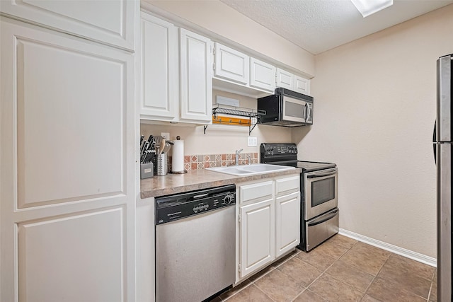 1860 White Oak Dr Unit 334, Houston, TX 77009 - kitchen featuring stainless steel appliances, white cabinetry, light countertops, and a textured ceiling