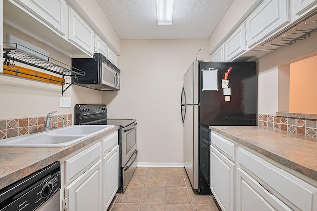 1860 White Oak Dr Unit 334, Houston, TX 77009 - kitchen featuring appliances with stainless steel finishes, white cabinetry, backsplash, a textured ceiling, and light tile patterned floors