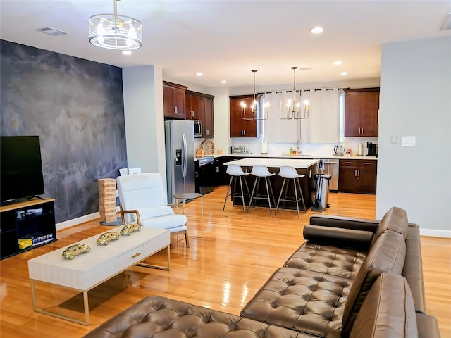 3333 Kilgore St, Houston, TX 77021 - living room featuring light wood-type flooring, recessed lighting, a chandelier, and an accent wall