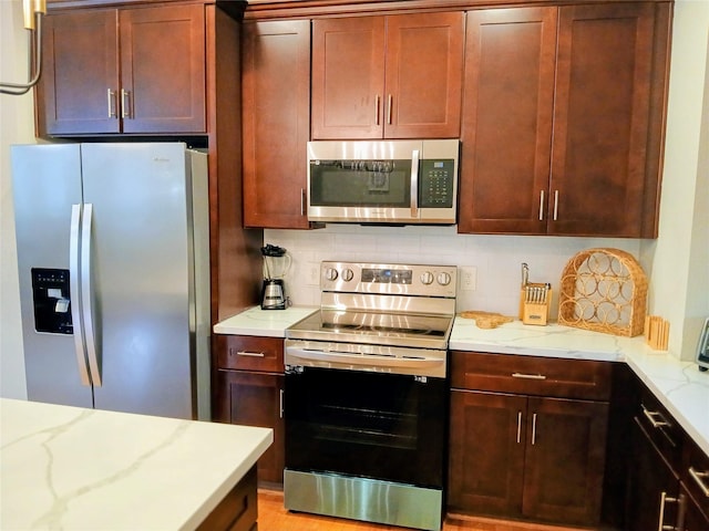 3333 Kilgore St, Houston, TX 77021 - kitchen featuring appliances with stainless steel finishes, backsplash, and light stone counters
