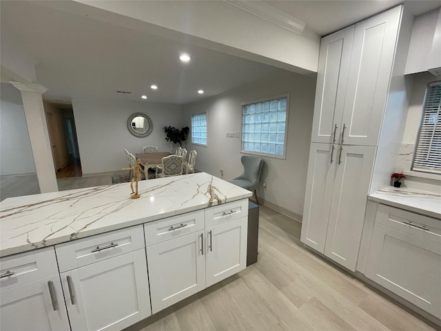 12834 Tosca Ln, Houston, TX 77024 - kitchen with recessed lighting, light wood finished floors, light stone countertops, and white cabinetry