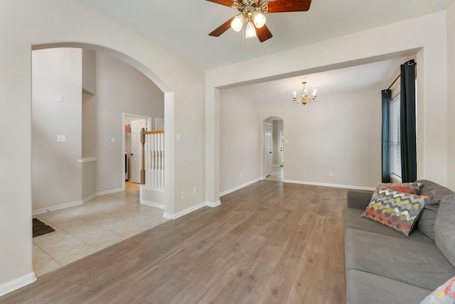 3202 Stoneydale Ln, Spring, TX 77388 - unfurnished living room featuring arched walkways, light wood-style flooring, a ceiling fan, and a chandelier
