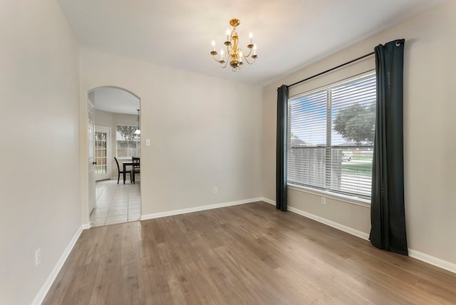 3202 Stoneydale Ln, Spring, TX 77388 - empty room with a chandelier, arched walkways, and wood finished floors