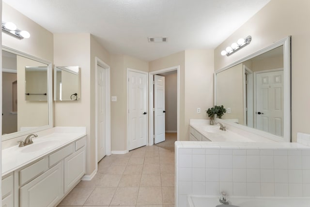 3202 Stoneydale Ln, Spring, TX 77388 - bathroom with two vanities, tile patterned flooring, and a bathtub