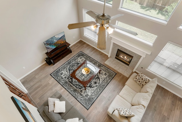3202 Stoneydale Ln, Spring, TX 77388 - living area featuring a ceiling fan, a high ceiling, wood finished floors, and a tiled fireplace