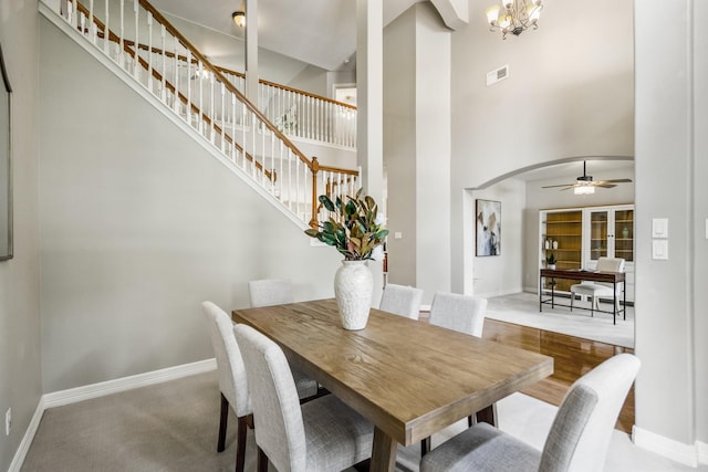 16407 Bogan Flats Ct, Houston, TX 77095 - dining space with a towering ceiling, stairway, arched walkways, a ceiling fan, and a chandelier