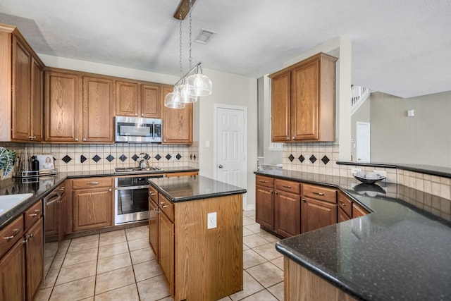 16407 Bogan Flats Ct, Houston, TX 77095 - kitchen with appliances with stainless steel finishes, a kitchen island, tasteful backsplash, brown cabinetry, and pendant lighting