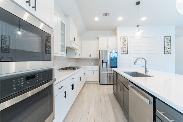 14811 Opossum Branch Ct, Cypress, TX 77433 - kitchen with stainless steel appliances, light countertops, decorative backsplash, hanging light fixtures, and glass insert cabinets
