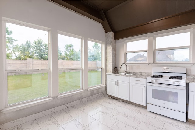 14811 Opossum Branch Ct, Cypress, TX 77433 - kitchen with white range with gas stovetop, light marble finish floors, white cabinets, and light stone counters