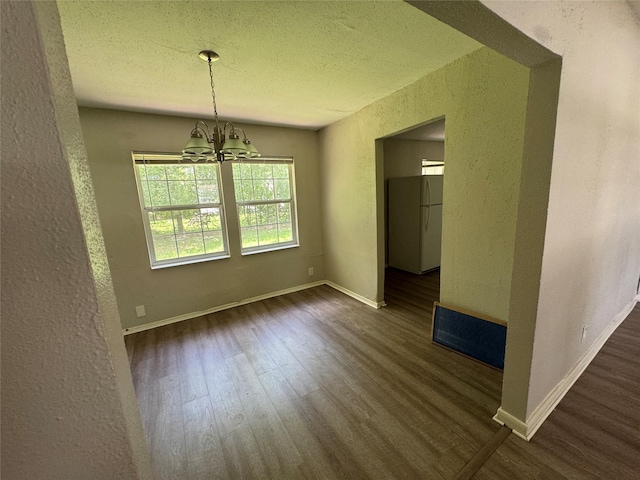 2222 8th St, Houston, TX 77547 - unfurnished dining area featuring a textured wall, wood finished floors, a chandelier, and a textured ceiling
