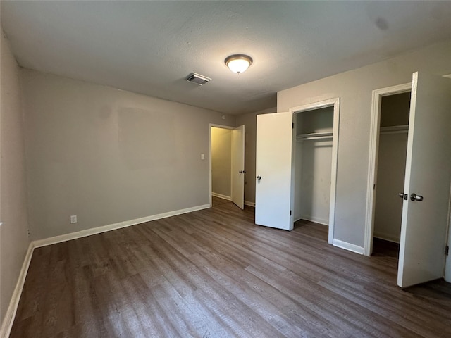 2222 8th St, Houston, TX 77547 - unfurnished bedroom with dark wood finished floors and multiple closets