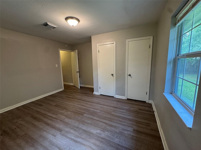 2222 8th St, Houston, TX 77547 - unfurnished bedroom featuring two closets and wood finished floors