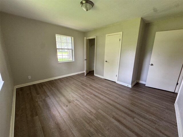 2222 8th St, Houston, TX 77547 - unfurnished bedroom with dark wood-type flooring and baseboards