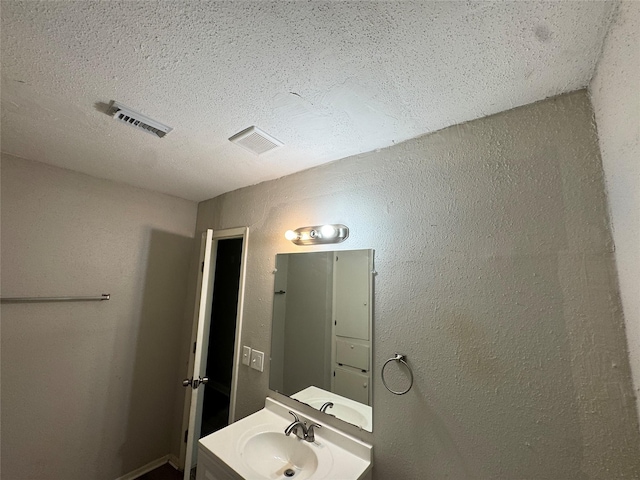 2222 8th St, Houston, TX 77547 - bathroom with a textured ceiling, vanity, and a textured wall