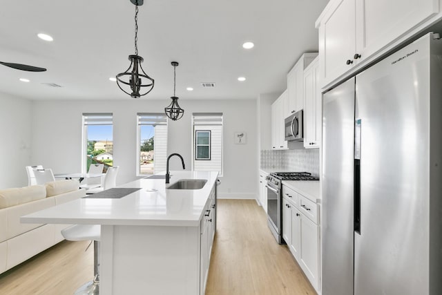 104 E 44th St Unit A, Houston, TX 77018 - kitchen featuring stainless steel appliances, light wood-style floors, recessed lighting, and white cabinetry