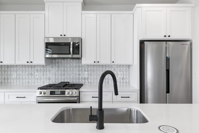104 E 44th St Unit A, Houston, TX 77018 - kitchen with appliances with stainless steel finishes, light countertops, white cabinets, and tasteful backsplash