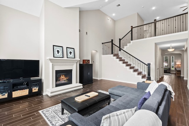 6303 Grand Drift Ct, Katy, TX 77494 - living room featuring high vaulted ceiling, wood tiled floors, stairs, a glass covered fireplace, and recessed lighting