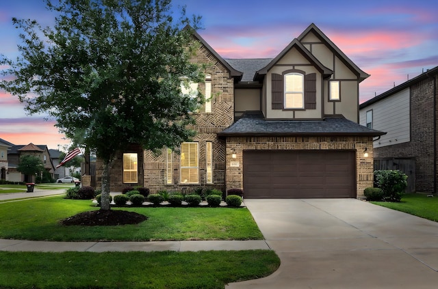 6303 Grand Drift Ct, Katy, TX 77494 - tudor-style house with brick siding, a garage, driveway, a front lawn, and stucco siding