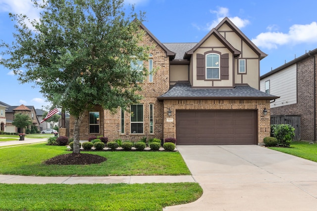 6303 Grand Drift Ct, Katy, TX 77494 - tudor home featuring a shingled roof, brick siding, a garage, concrete driveway, and stucco siding