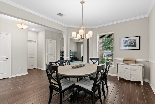 6303 Grand Drift Ct, Katy, TX 77494 - dining space featuring dark wood-style floors, a chandelier, ornamental molding, and arched walkways