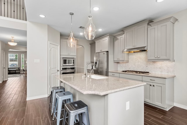6303 Grand Drift Ct, Katy, TX 77494 - kitchen with stainless steel appliances, recessed lighting, wood finish floors, under cabinet range hood, and backsplash